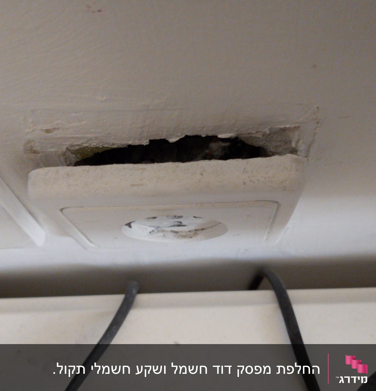 שקע חשמל בקיר עם חוטי חשמל חשופים